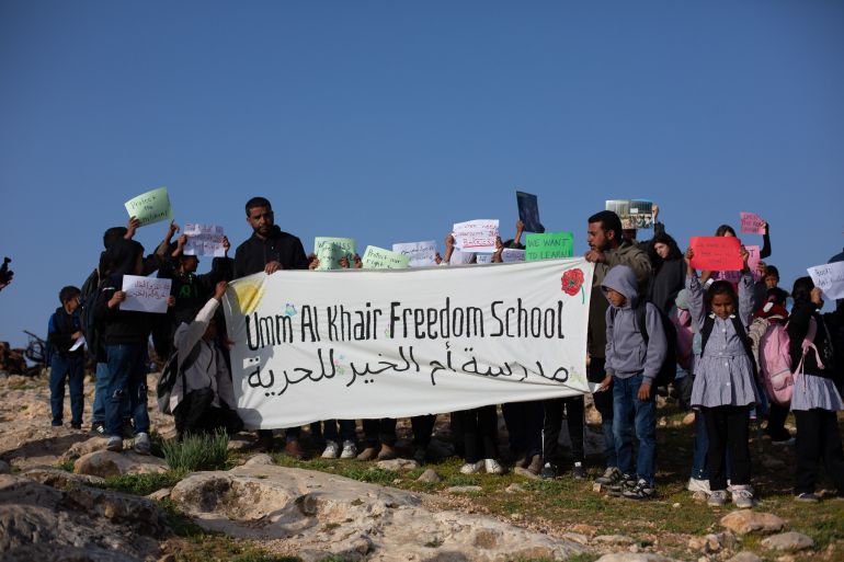 Children march to school blocked by settler fence in West Bank.