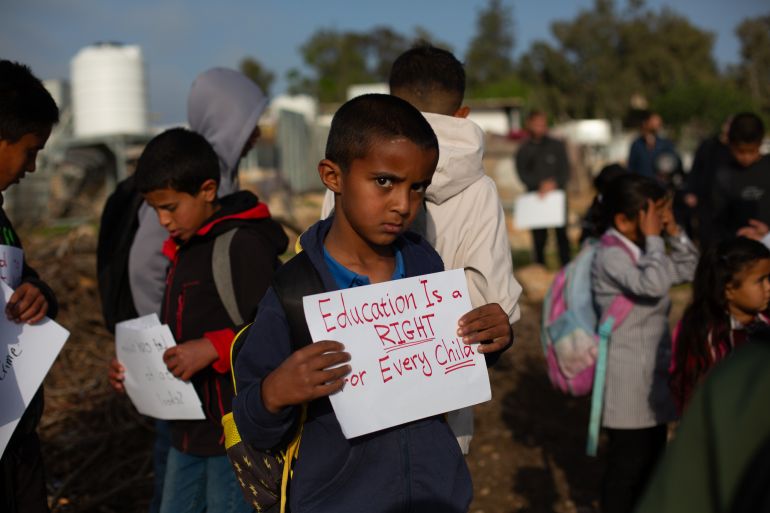 Children march to school blocked by settler fence in West Bank.